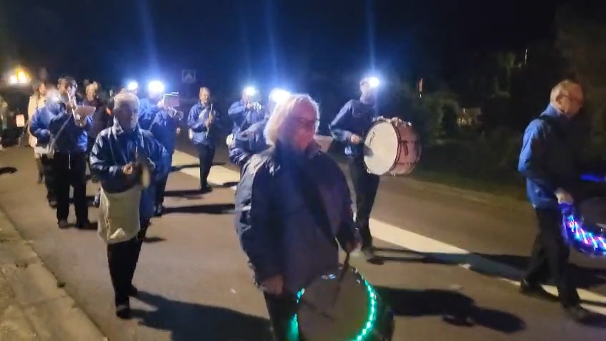 La fanfare en tête du cortège, tambours illuminés.